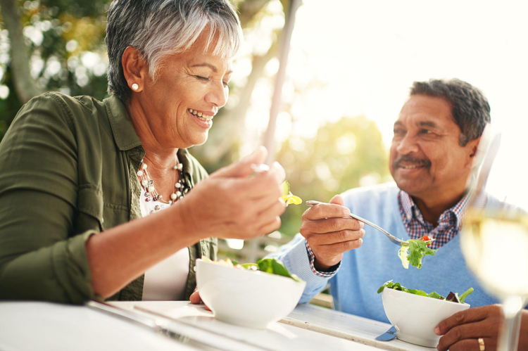 Senior-Couple-Eating-Salad-Outdoors